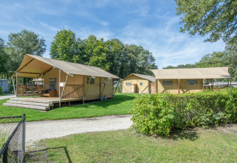 Safari tents at Holiday Park Klein Vink 19 in the Netherlands, surrounded by green lawns and trees.