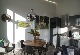 Cucina moderna e zona pranzo di una tiny house presso Holiday Park De Rimboe & De Woeste Hoogte 41 nei Paesi Bassi.