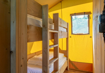 Interior de tienda safari con litera de madera y ventana en Holiday Park Klein Vink 19, Países Bajos.