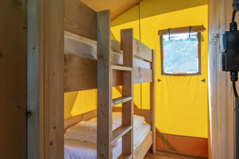 Interior de tienda safari con litera de madera y ventana en Holiday Park Klein Vink 19, Países Bajos.