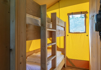 Interior of a safari tent with wooden bunk bed and window at Holiday Park Klein Vink 19 in the Netherlands.