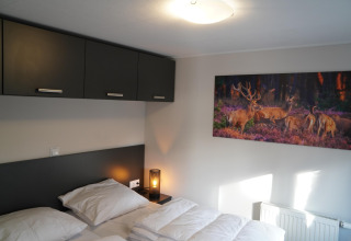 Chambre moderne au Holiday Park De Rimboe & De Woeste Hoogte 41 avec photo de cerfs et armoires élégantes.
