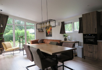 Modern living and kitchen area in a lodge at Holiday Park De Rimboe & De Woeste Hoogte 25 in the Netherlands