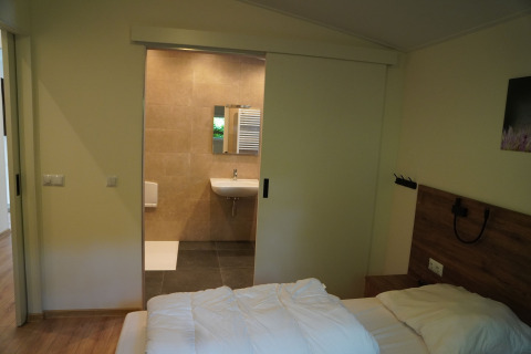 Schlafzimmer mit Blick auf das Badezimmer im Holiday Park De Rimboe & De Woeste Hoogte 25, Niederlande.