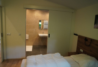 Schlafzimmer mit Blick auf das Badezimmer im Holiday Park De Rimboe & De Woeste Hoogte 25, Niederlande.