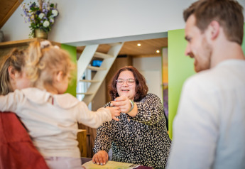 Receptionist welcomes a child and family at Holiday Park De Rimboe & De Woeste Hoogte 25 in the Netherlands.