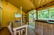 Interno di una tenda safari al Country Estate Gerner 8 nei Paesi Bassi, con arredi rustici in legno.