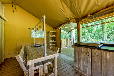 Interior of a safari tent at Country Estate Gerner 8 in the Netherlands, featuring rustic wooden furniture.