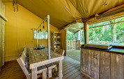 Interior of a safari tent at Country Estate Gerner 8 in the Netherlands, featuring rustic wooden furniture.