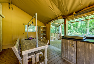 Interior of a safari tent at Country Estate Gerner 8 in the Netherlands, featuring rustic wooden furniture.