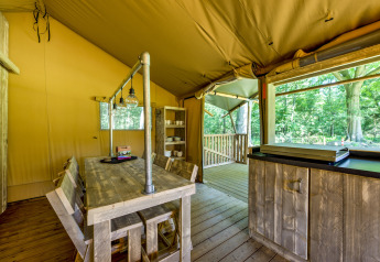 Interior of a safari tent at Country Estate Gerner 8 in the Netherlands, featuring rustic wooden furniture.