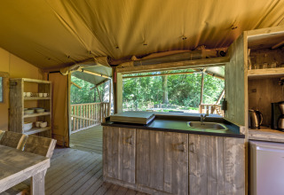 Binnenaanzicht van een safaritentkeuken op Country Estate Gerner 8, Nederland, met houten meubels.