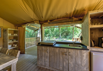 Interior view of a rustic safari tent kitchen at Country Estate Gerner 8 in the Netherlands, wood furnishings.