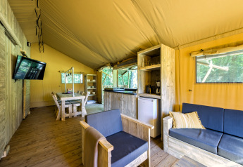 Interno di tenda safari moderna presso Country Estate Gerner 8 nei Paesi Bassi, con arredi in legno chiaro.