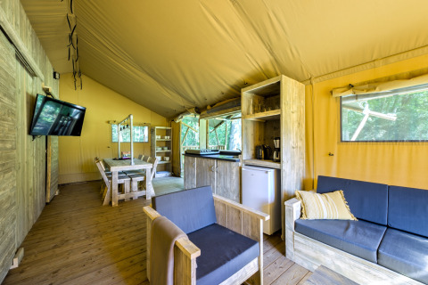 Interno di tenda safari moderna presso Country Estate Gerner 8 nei Paesi Bassi, con arredi in legno chiaro.