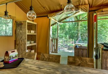 Interior of the Country Estate Gerner 8 safari tent in the Netherlands with wood decor and forest view.