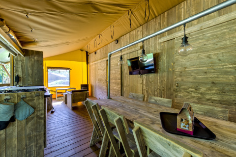 Interior of the Country Estate Gerner 8 safari tent in the Netherlands, with rustic wood decor and table.