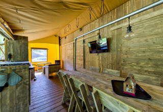Interior of the Country Estate Gerner 8 safari tent in the Netherlands, with rustic wood decor and table.