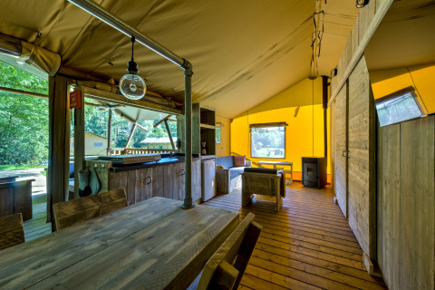 Innenraum eines Safarizelts im Country Estate Gerner 8 in den Niederlanden mit Holzmöbeln und gemütlicher Atmosphäre.