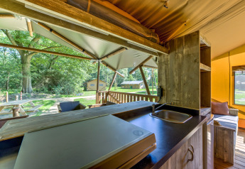 Vista dalla cucina di una tenda safari al Country Estate Gerner 8 con terrazza e verde circostante.