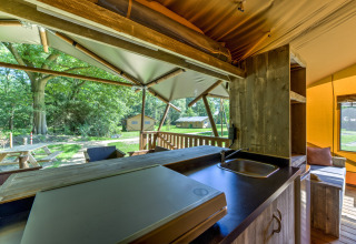 Vista dalla cucina di una tenda safari al Country Estate Gerner 8 con terrazza e verde circostante.