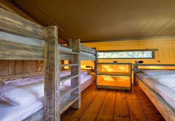 Interno di tenda safari al Country Estate Gerner 8 nei Paesi Bassi, letti a castello in legno rustico.