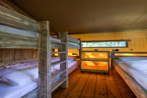 Interior of a safari tent at Country Estate Gerner 8, Netherlands, featuring cozy wooden bunk beds.
