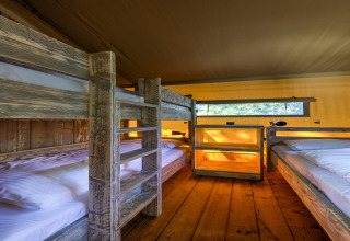 Interior of a safari tent at Country Estate Gerner 8, Netherlands, featuring cozy wooden bunk beds.