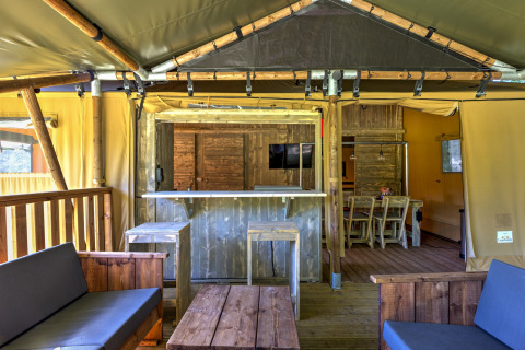 Interior view of a safari tent at Country Estate Gerner 8 in the Netherlands with rustic wood furniture.