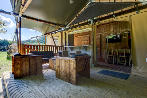 Safari tent Country Estate ‘Gerner 8’ with wooden furniture and covered terrace in the Netherlands.