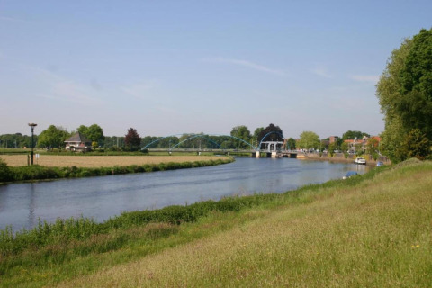 View of the river, bridge, boats, and green fields from Country Estate Gerner 8 in the Netherlands.