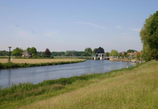 View of the river, bridge, boats, and green fields from Country Estate Gerner 8 in the Netherlands.