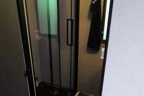 Indvendigt billede af brusebadet i mobilhjemmet Sunhouse Bodhi i Holland med glasdør.