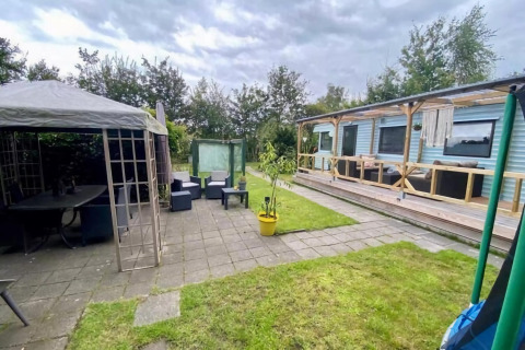 Udendørs område ved mobilhjemmet Sunhouse Bodhi i Holland med overdækket terrasse og afslapningshjørne.