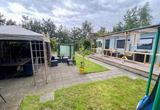 Udendørs område ved mobilhjemmet Sunhouse Bodhi i Holland med overdækket terrasse og afslapningshjørne.