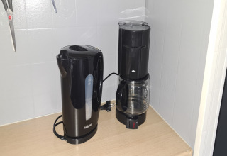 Elkedel og kaffemaskine på en træbordplade i et mobilhome kaldet 'Sunhouse Bodhi' i Holland.