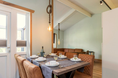 Eettafel met stijlvol servies en lederen stoelen in lodge Residence De Eese 3 in Nederland.