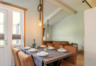 Eettafel met stijlvol servies en lederen stoelen in lodge Residence De Eese 3 in Nederland.