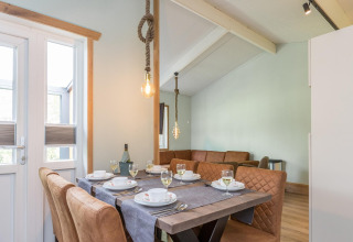 Eettafel met chique servies en leren stoelen bij lodge Residence De Eese 3 in Nederland.