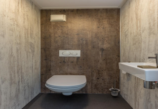 Modern, minimalistisch toilet met wandcloset en kleine wastafel in Residence De Eese 3 in Nederland.