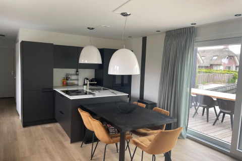 Moderne Küche und Essbereich in einer Lodge im Recreation Park Idskenhuizen, Niederlande, mit Terrassenzugang.