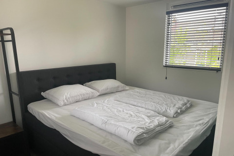 Schlafzimmer in Recreation Park Idskenhuizen 11, Niederlande, mit Doppelbett und Fenster.