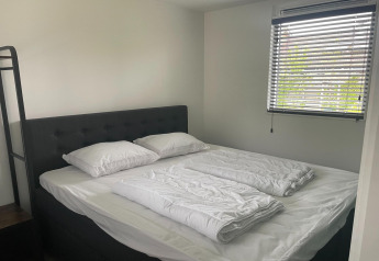 Dormitorio en Recreation Park Idskenhuizen 11, Países Bajos, con cama doble y persianas en la ventana.