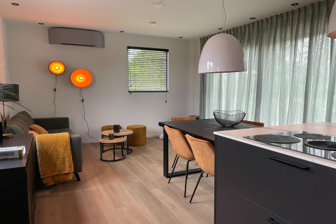 Modernes Wohn- und Esszimmer in einer Lodge im Recreation Park Idskenhuizen 11, Niederlande, mit stilvollem Dekor.