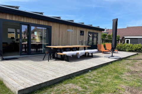 Außenterrasse der Lodge im Erholungspark «Idskenhuizen 11» in den Niederlanden mit Sitzgelegenheiten.