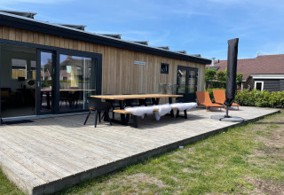 Außenterrasse der Lodge im Erholungspark «Idskenhuizen 11» in den Niederlanden mit Sitzgelegenheiten.