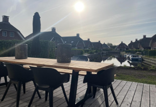 Terrasse im Erholungspark Idskenhuizen 11, Niederlande, mit modernen Möbeln und Blick auf den Kanal.