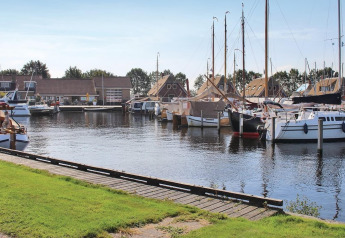 Barcos atracados y cabañas modernas junto al puerto en Recreation Park Idskenhuizen 11, Países Bajos.