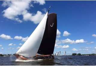 Sejlbåd deltager i en kapsejlads på en sø under blå himmel ved Recreation Park Idskenhuizen, Holland.