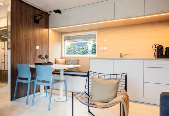 Moderne hytte med åbent køkken, spiseplads og lyst interiør, set i Chalet «Imke» i Holland.